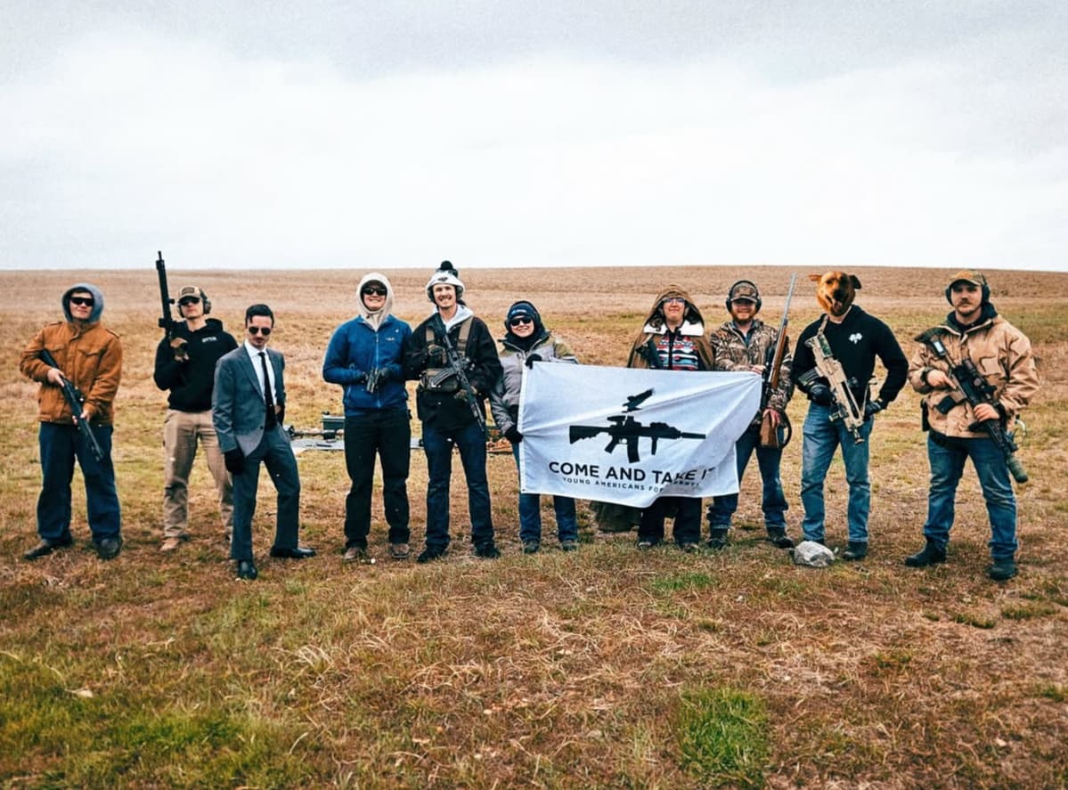 YAL members at a chapter range day holding a Come and Take It flag